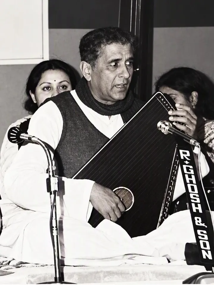 Pandit Chandrakant Apte singing at a concert, a swarmandal on his lap